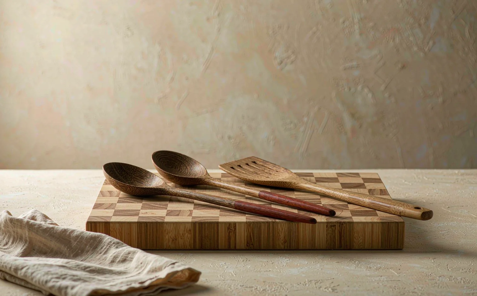 End-grain bamboo cutting board with hand-carved wooden spoons